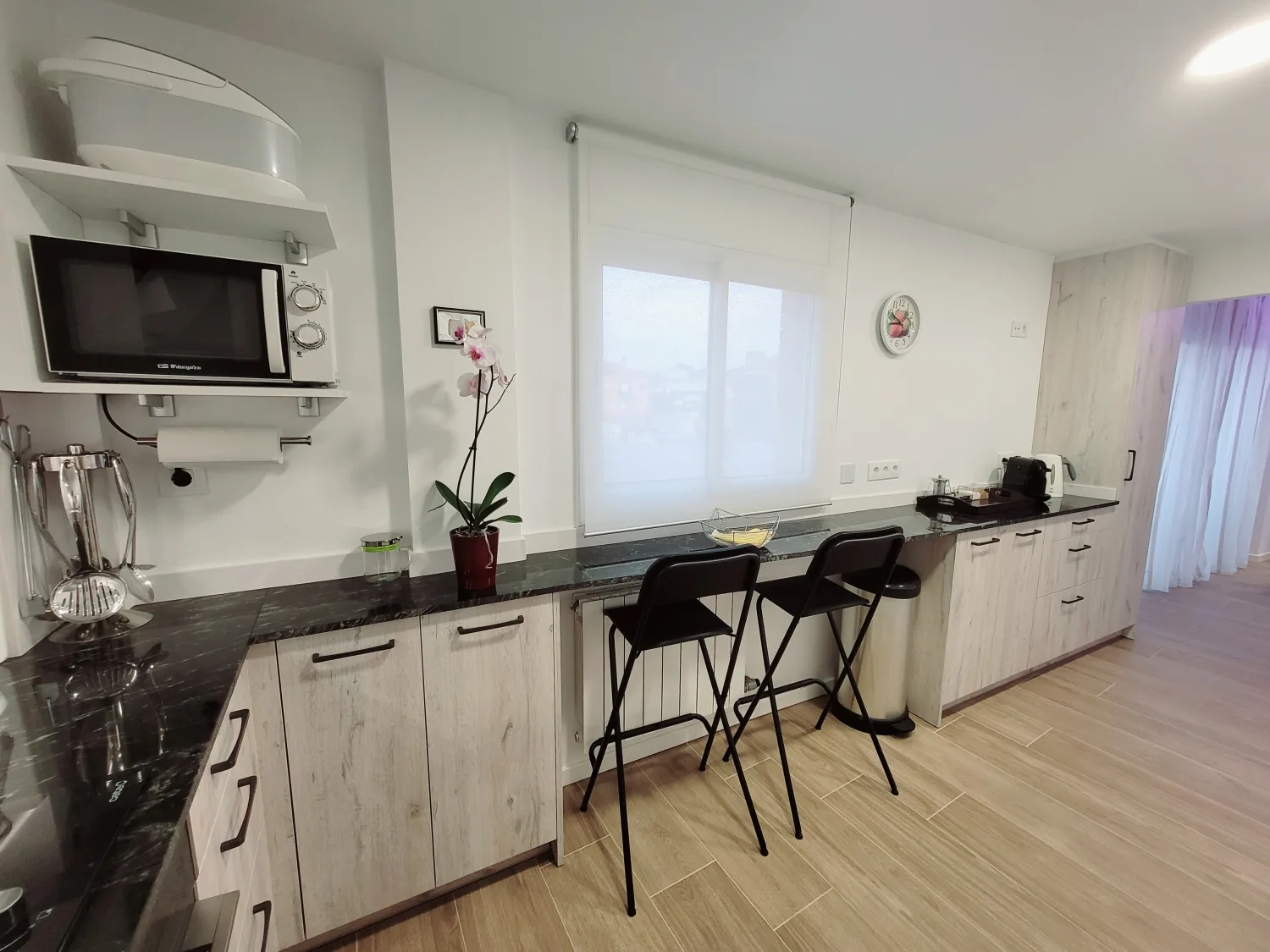 Zona d'emmagatzematge i racó de cafè amb vistes a la cuina