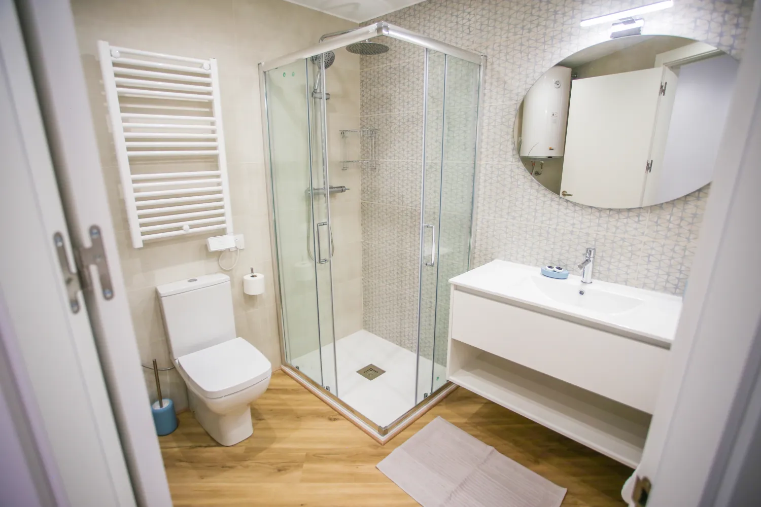 Baño reformado con mampara de cristal y mueble de madera