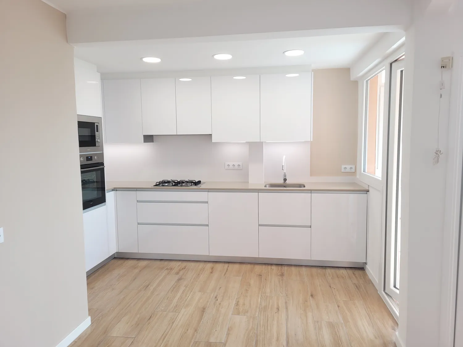 Cocina reformada en blanco con electrodomésticos integrados