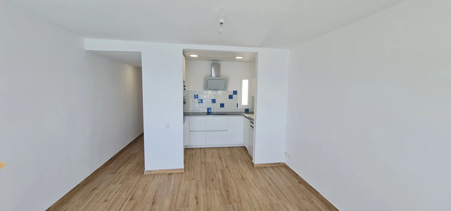 Open kitchen with white and blue tiles by the sea